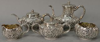 Sterling silver five piece tea and coffee set having repousse tops and bodies. 
largest: height 8 inches 
68.8 troy ounces