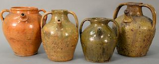 Four redware pots with handles and spouts, probably Continental. 
heights 10 inches to 13 inches