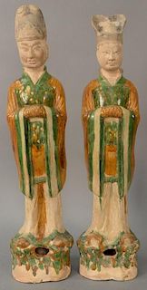 Two large sancai glazed pottery figures, Tang Dynasty (618-907), each shown standing on a rockwork plinth. 
(both with restor