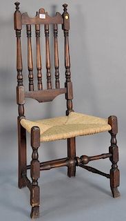 Bannister back side chair with carved crest, rush seat, and bold turned stretcher on Spanish feet.  height 43 1/2 inches, sea
