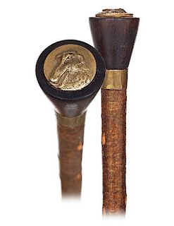 69. Countryside Cane -Ca. 1920 -Plain turned black horn knob embellished with a round bronze shield modeled and cast with the