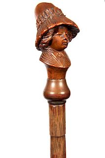 143. Female Portrait Wooden Cane- Ca. 1900- A realistic carving of a lady in a very large attractive hat, faux bamboo partrid
