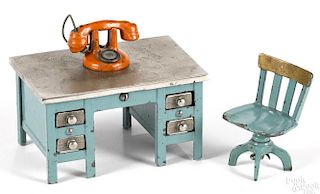 Kenton cast iron blue knee hole desk, 2 3/4'' h., with a telephone and a swivel chair.