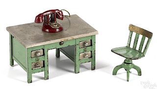 Kenton cast iron green knee hole desk, 2 3/4'' h., with a telephone and a swivel chair.