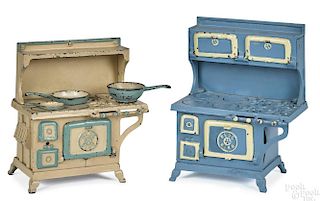 Two Grey Iron Blue Bird cast iron stoves, one with three miniature pots and pans, 10 1/4'' h.