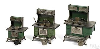 Three Kenton cast iron stoves with numerous pots and pans, in graduated sizes, 10 1/2'' h.