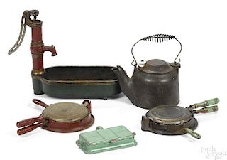 Four Arcade cast iron toys, to include a water pump and trough, 8'' h., and three waffle irons