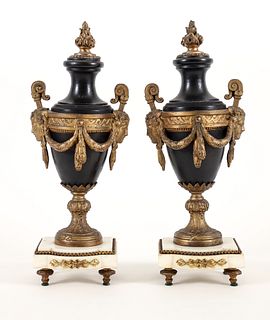 Pair of classical metal urns on white marble bases