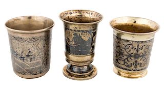 A GROUP OF THREE ANTIQUE RUSSIAN GILT SILVER AND NIELLO CUPS, VARIOUS MAKERS, MOSCOW, 1830S-1850S