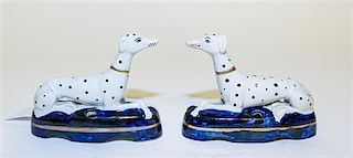 * A Pair of Staffordshire Reclining Dalmation Figurines Height 4 x width 4 1/2 inches.