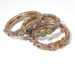 A collection of three gem and gold bangles
