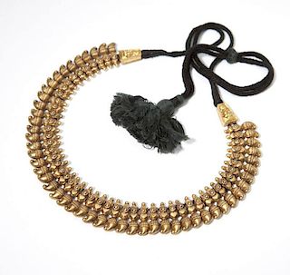 An Indian gold sectional necklace on black cord