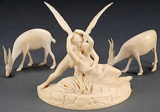 A EUROPEAN CARVED IVORY GROUPING DEPICTING CUPID