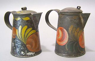 Two black toleware syrup pitchers, 19th c., with r