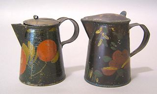 Two black toleware syrup pitchers, 19th c., with f