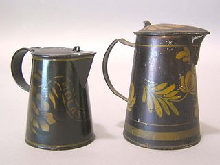 Two black toleware syrup pitchers, 19th c., with y