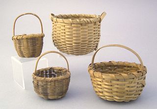 Four miniature woven handled baskets.