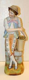 Porcelain statue of a boy with fruit basket