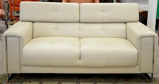 Modern tan leather loveseat with chrome feet and frame.