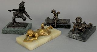 Four bronze figures including cherub seated on folded paper marked Ferrand, a boy laying holding a bird marked Ano More... on