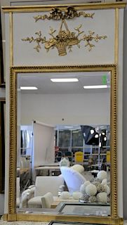 French style trumeau mirror having white with parcel gilt painted frame and  top frieze with carved gilt basket of a flower d