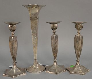 Four weighted sterling silver pieces including three candlesticks and a tall vase.