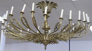 Large twenty-four light brass chandelier having twenty-four outstretched arms and scrolling leaves holding candle light socke