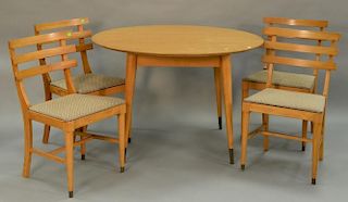 Modern oak table and four chairs plus two 12" leaves. ht. 29in., dia. 44in., total open: 44" x 67"