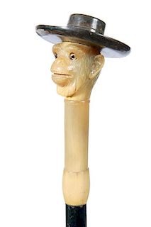 3. Horn Monkey Dress Cane-Ca 1900- A realistic carved monkey with  realistic glass eyes, a black horn large brim hat atop, ho