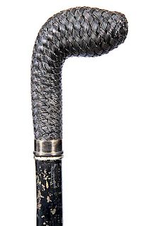 89. Spring Hilt Sword Cane- Ca. 1890- A wire woven handle, silver metal collar, a spring hilt 28 ½” engraved blade, exotic
