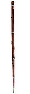 121. Flute Cane- Ca. 1870- An exotic wood flute cane with a pommel handle that turns to tune the flute, a pair of bone eyelet