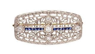 * An Edwardian Platinum Topped Gold, Diamond and Sapphire Filigree Brooch, 5.50 dwts.