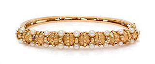 * A 14 Karat Yellow Gold and Cultured Pearl Bangle Bracelet, Jack Gutschneider Co., 10.35 dwts.