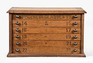 An oak six drawer crystal cabinet loaded with watch parts and jewelers findings