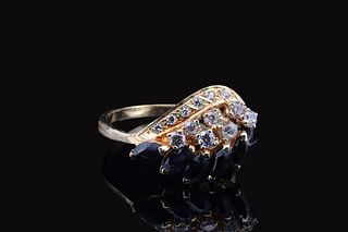 A gold ring with a curved design, featuring a row of dark blue sapphires flanked by sparkling Zircones