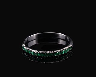 A white gold band ring channel-set with a continuous line of round-cut Emeralds.