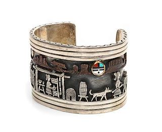 A Navajo Silver and 14 Karat Yellow Gold Storyteller Bracelet, Clarence Lee Length 4 3/4 x opening 1 1/8 x width 1 1/2 inches