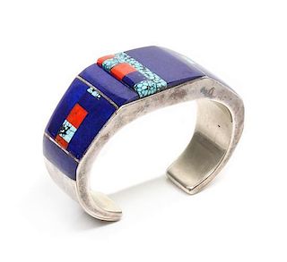 A Zuni Silver, Lapis, Turquoise and Coral Bracelet, Roger Tsabetsaye Length 4 7/8 x opening 7/8 x width 1 inches.