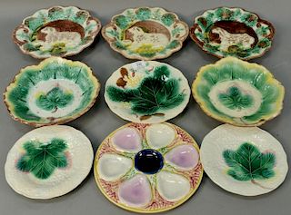 Nine piece Majolica lot including three serving plates with dogs, five with leaves including two shallow bowls and three plat