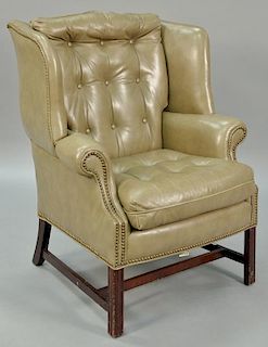 Leather upholstered wing chair on Chippendale style base.