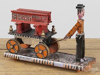 Contemporary carved and painted folk art figure pulling a cart of beams, inscribed Bethlehem Steel