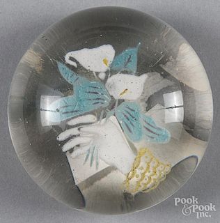 Colored frit paperweight, with a hand holding lilies, 3 1/2'' dia.