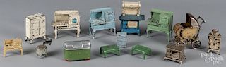 Thirteen pieces of Arcade cast iron dollhouse furniture, together with a Kilgore baby carriage, tall