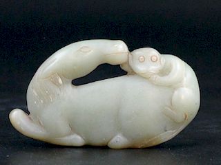 Chinese jade carving of a monkey riding on a horse.
