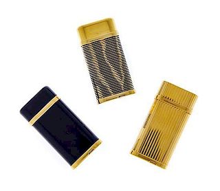 Three Gold-Plate Lighters, Cartier, Circa 1970, comprising one with vertically ribbed body and cover, another with horizontal ri
