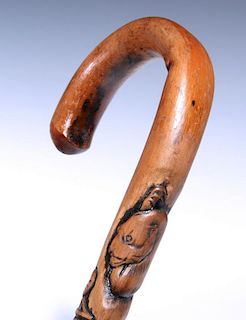 AN EARLY 20TH CENTURY CANE WITH FOLKY CARVED ANIMALS