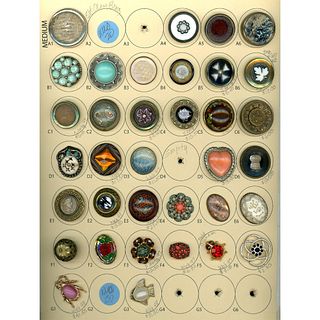 A card of assorted glass in metal buttons