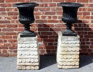 Pair of Cast Iron Urns on Painted Portland Bases.