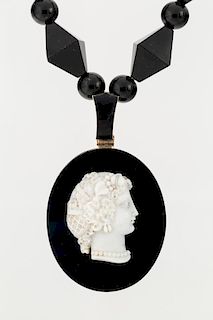 AN ONYX MOURNING LOCKET NECKLACE WITH CAMEO