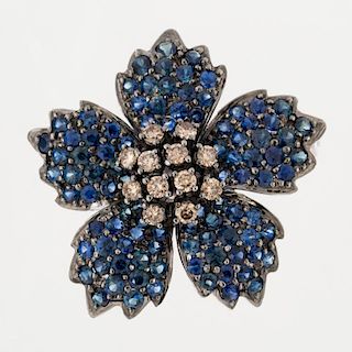 A SAPPHIRE AND CHAMPAGNE COLORED DIAMOND FLOWER BROOCH